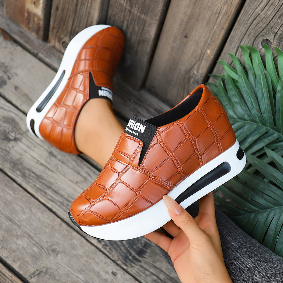 Brown crocodile pattern platform slip-on flats with a chunky white sole.