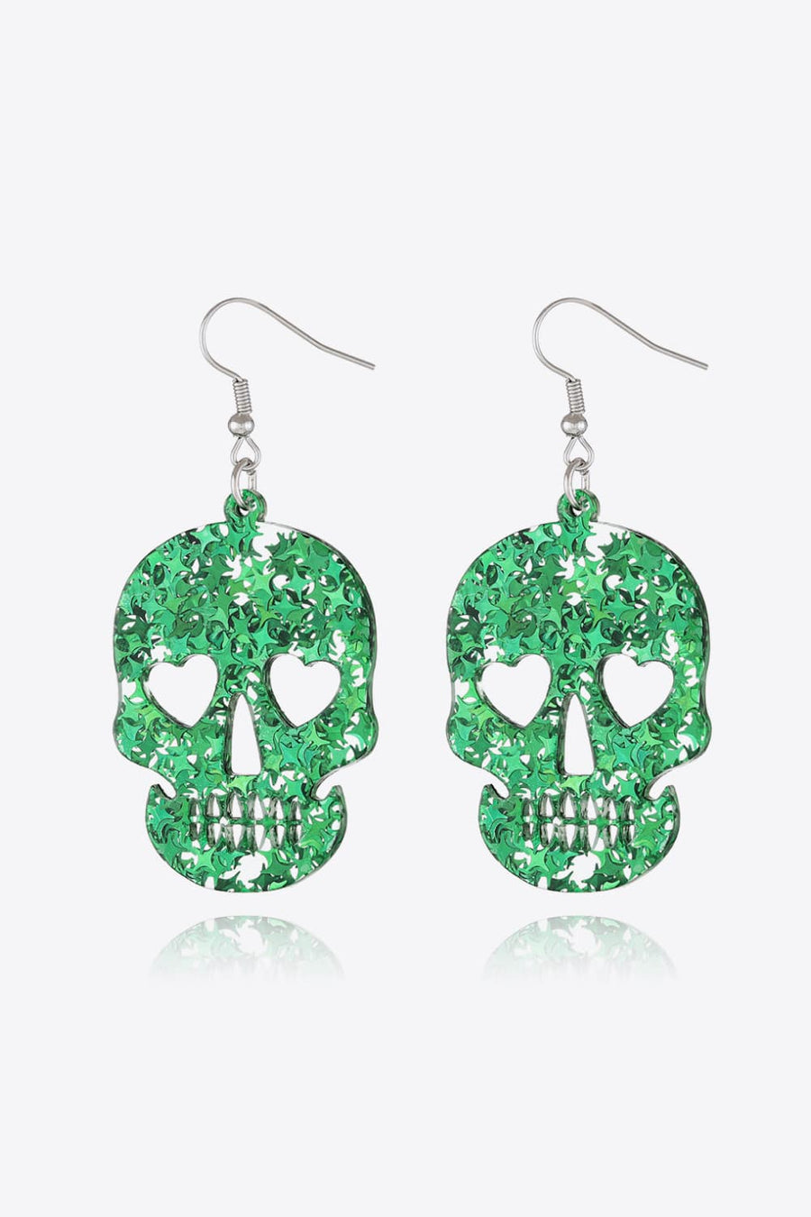 Green glitter skull earrings with heart eye cutouts and starburst pattern.