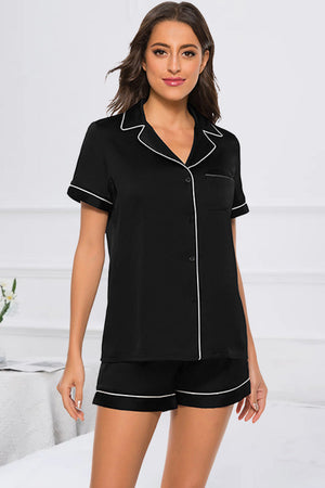 Black satin pajama set with white piping, button-up top and shorts.