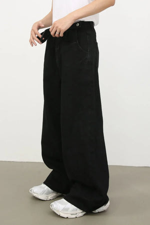 Black denim jeans with exaggerated wide legs and a tie detail.
