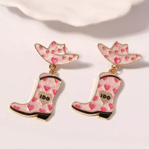 Pink cowgirl hat and boot dangle earrings with heart pattern and gold accents.