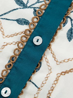 Cotton polo collar mini dress with chain and leaf print, button front, and decorative trim.