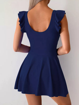 Navy blue ruffled sleeve asymmetric swim dress with a scoop neck and flared skirt.