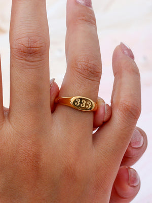 ring in gold with numeric motif and engraved detail
