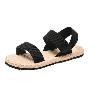 Black rope-sole cross-strap sandals with adjustable straps.