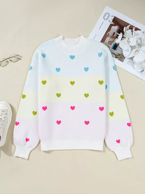 Playful heart pattern knit sweater with crew neck and colorblock design.