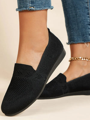 Black knit slip-on loafers with a textured pattern and low heel.