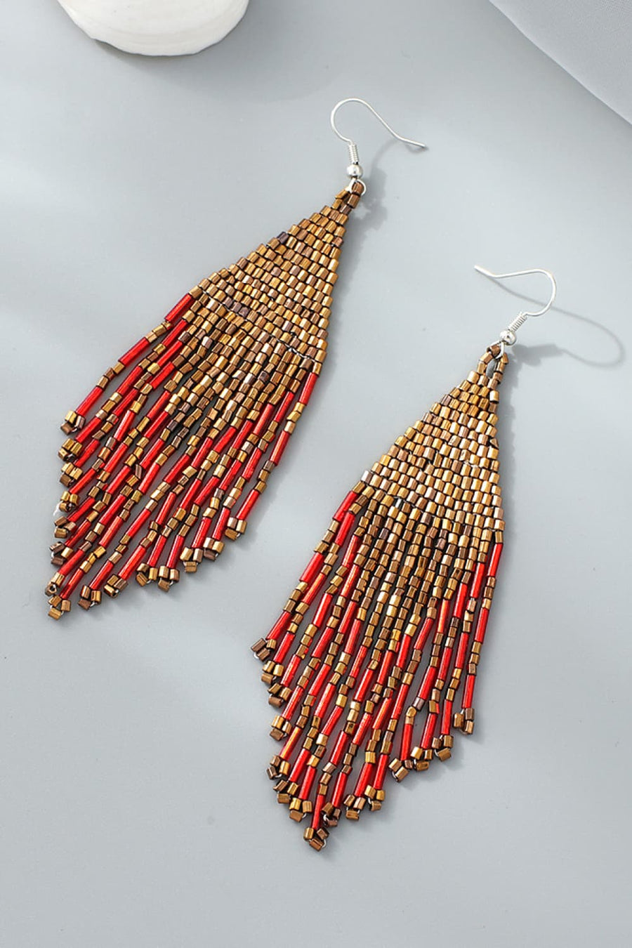 Prismatic beaded fringe earrings in gold and red with a cascading design.