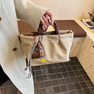 Compact nylon handbag in Khaki with leather accents and playful charms.
