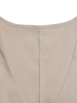 Beige sleeveless wrap top detail with V-neckline and center seam on polyester fabric.