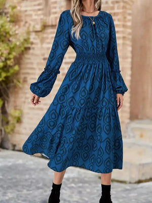 Blue abstract pattern smocked midi dress with balloon sleeves and tiered skirt.