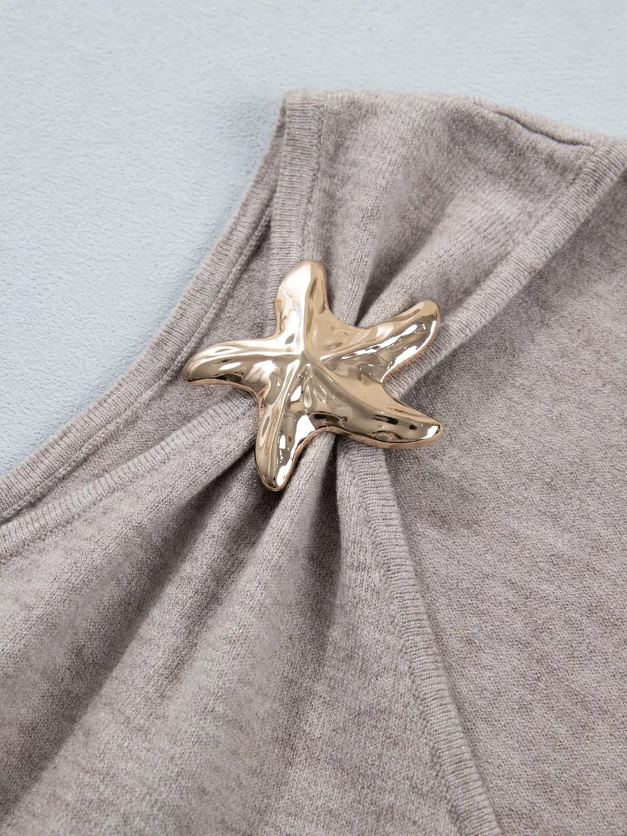 Grey V-neck knit vest with a gold starfish embellishment and draped detail.