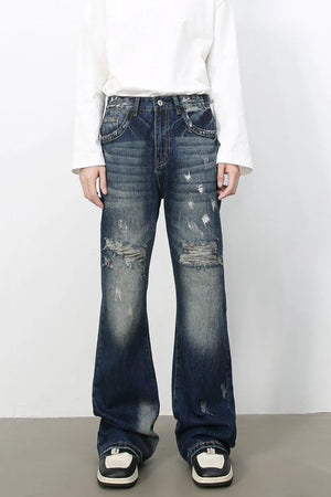 Distressed flare jeans in medium wash denim with raw edge finish and ripped details.