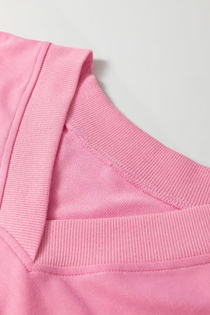 Pink cotton loungewear set with V-neck detail and ribbed trim.