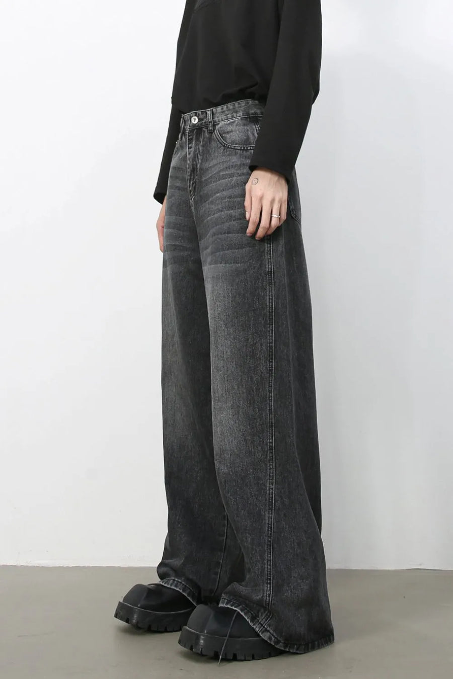 Dark wash denim trousers with exaggerated wide legs and a casual fit.