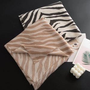 Wool scarf with zebra stripes in khaki and black, featuring fringed edges.