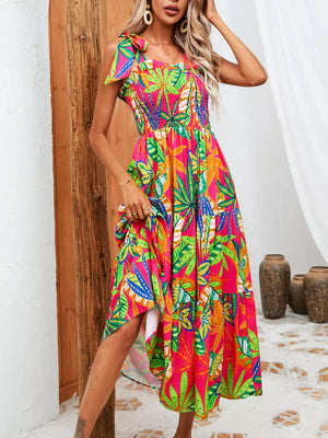 Tropical tie-strap smocked midi dress in strawberry with a vibrant leaf print, square neckline, and tiered skirt.
