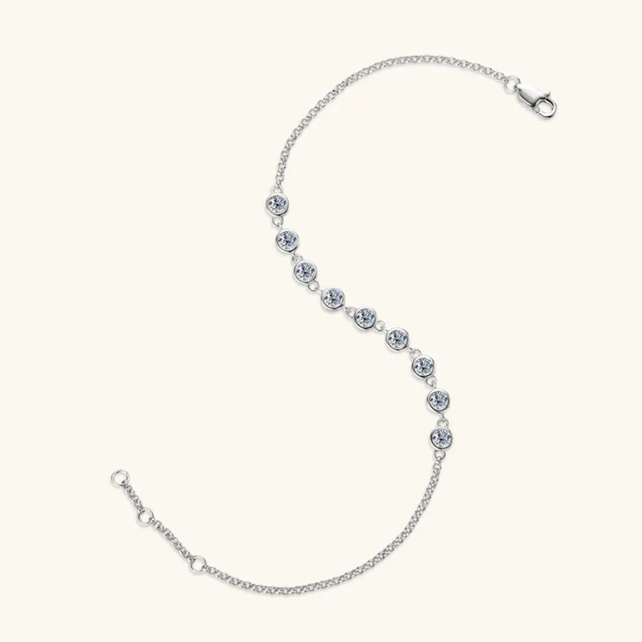 Silver moissanite tennis bracelet with bezel-set stones and a delicate chain.