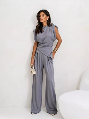 Gray satin cowl neck two-piece set with wide-leg pants and padded shoulders.