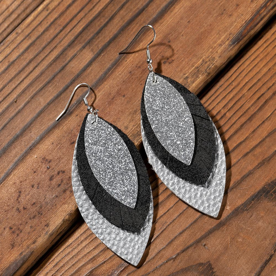 Layered faux leather statement earrings in silver and black with glitter detail.