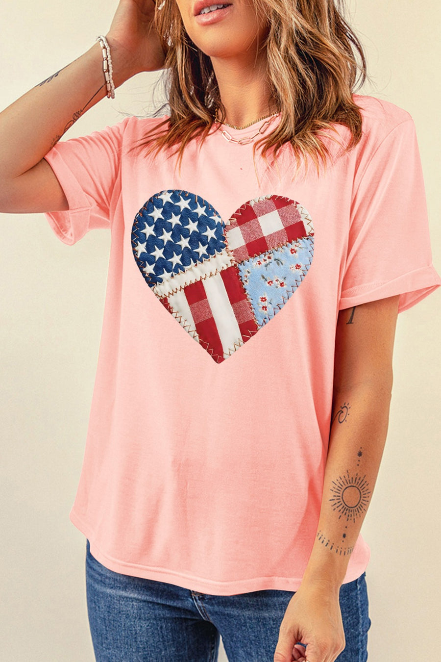 Pink t-shirt with a patriotic heart graphic made of patchwork American flag, gingham, and floral fabric.