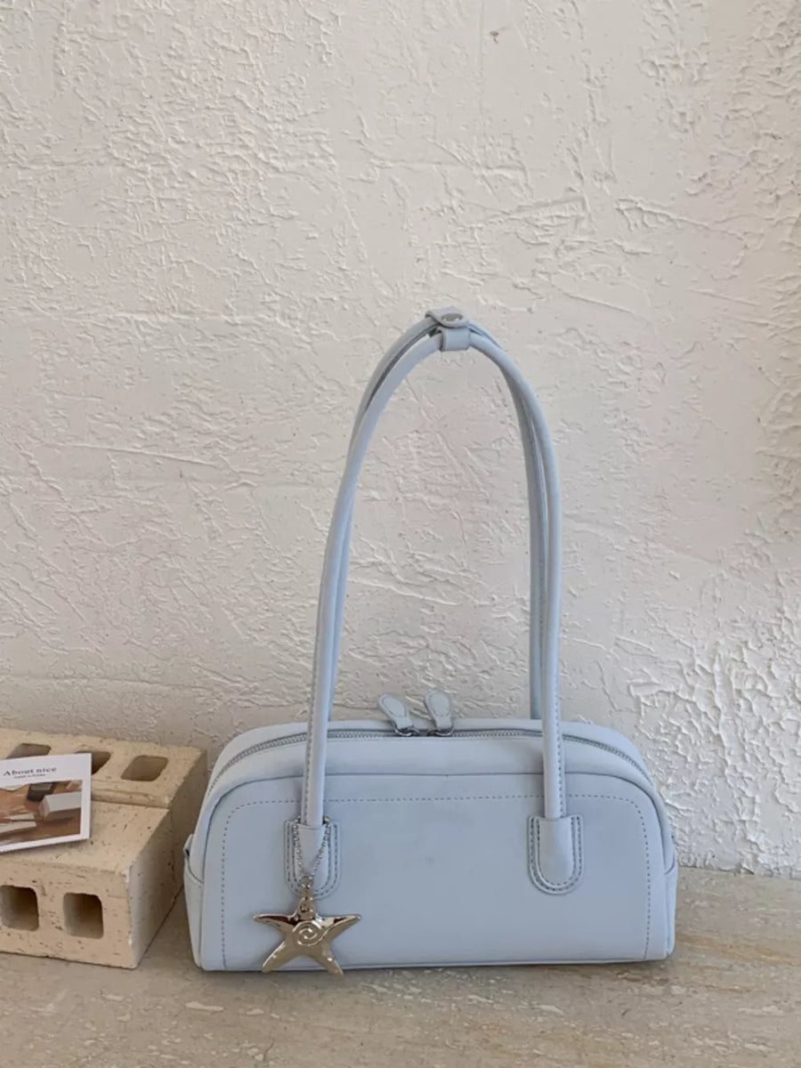 Light blue leather shoulder bag with star charm and double zipper.