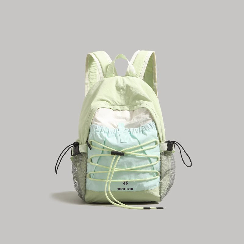 Lightweight drawstring nylon backpack in light green with bungee details and mesh side pockets.