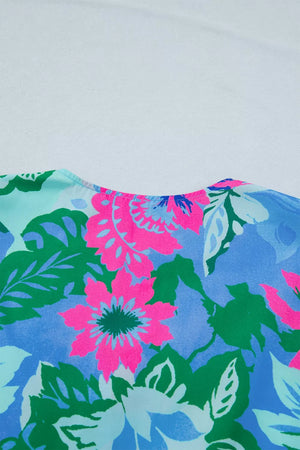 Vibrant floral v-neck blouse with pink, blue, green, and light blue flowers and leaves.