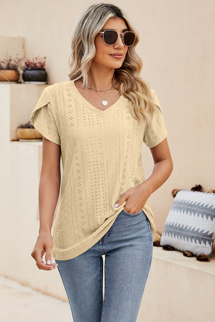 Light yellow knit top with perforated sleeve detail and v-neck