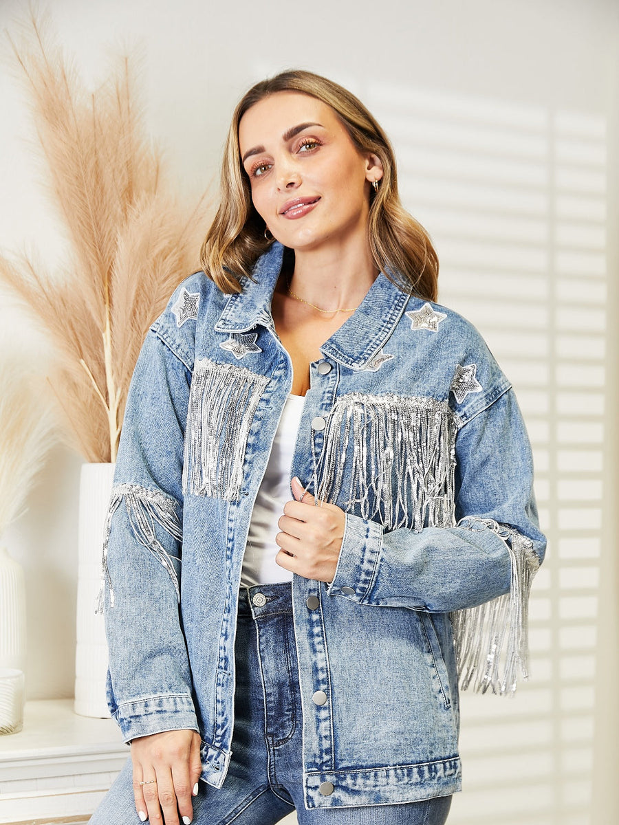 Light denim trucker jacket with star patches and silver fringe detail on shoulders and chest.
