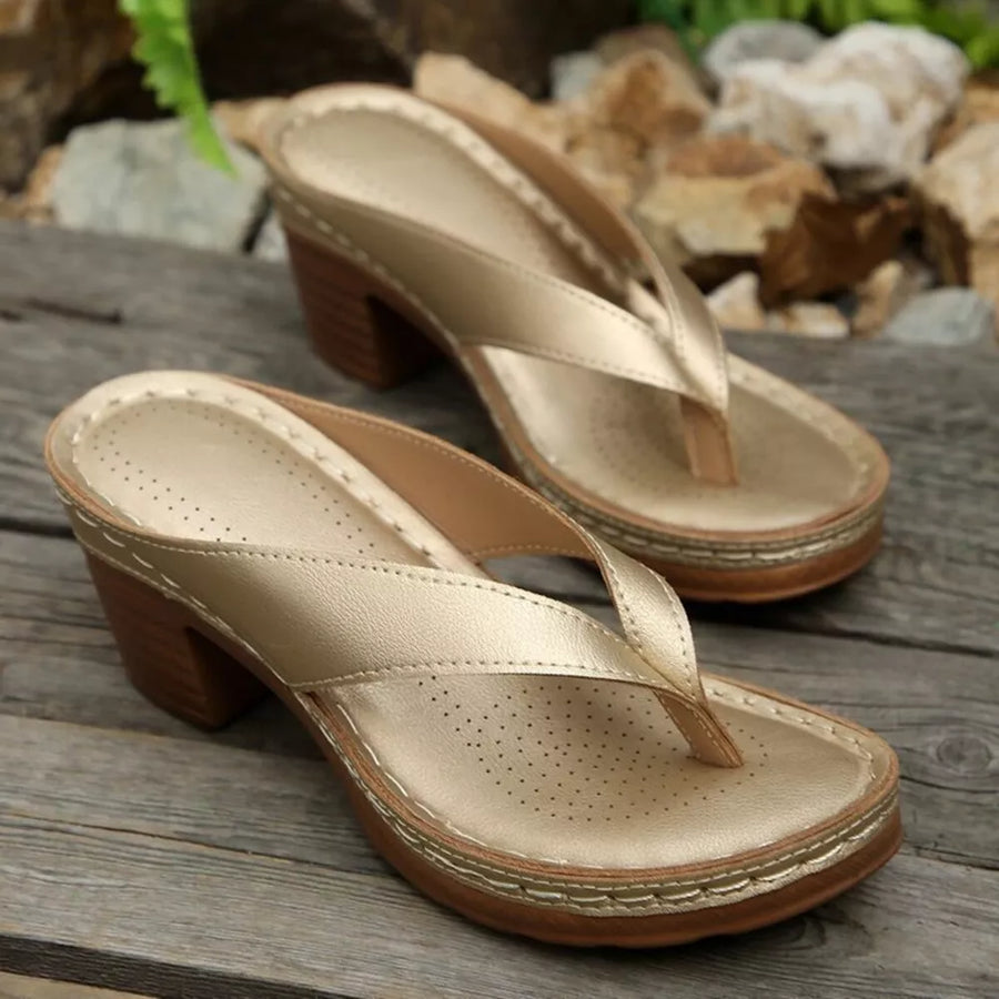 Gold toe-post block heel sandals with perforated insoles and contrast stitching.