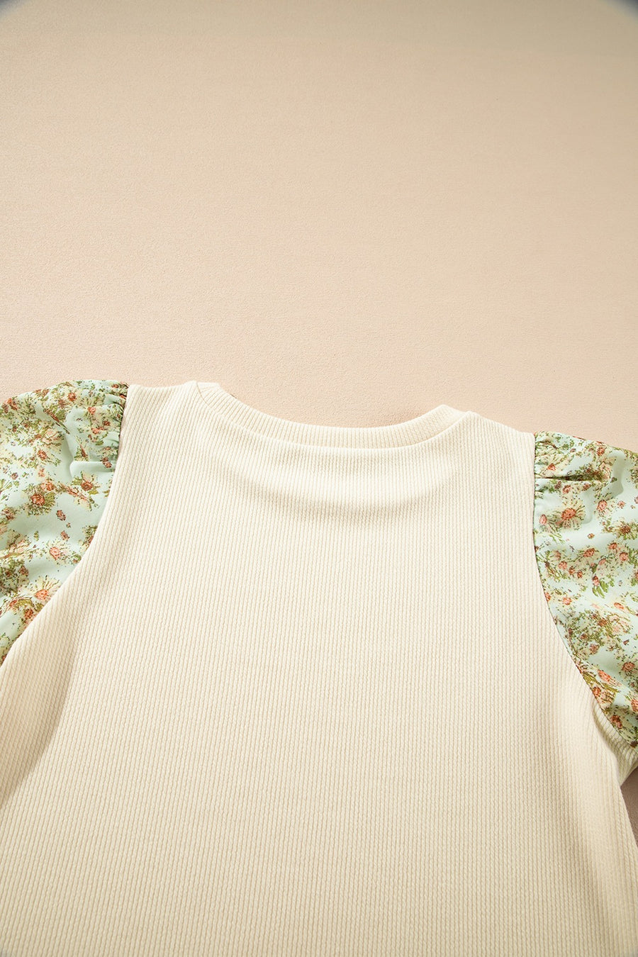 Beige ribbed knit top with floral puff sleeves and crew neck.