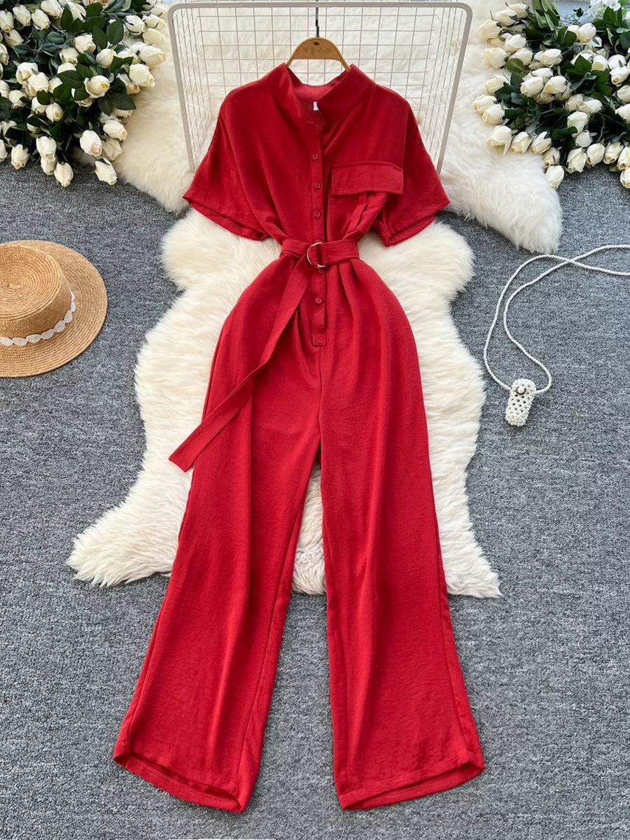 Red belted wide leg romper with short sleeves, button-down front, and pocket detail.