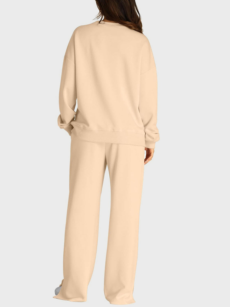 Tan loungewear set with crewneck sweatshirt and wide-leg trousers with slit-front detail.