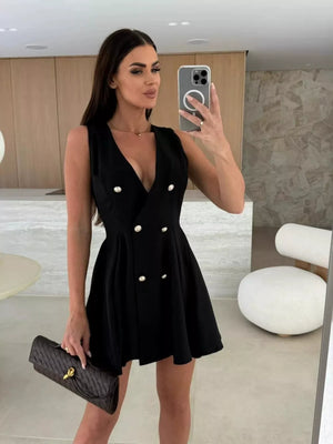 Black double-breasted mini dress with gold buttons and pleated skirt.