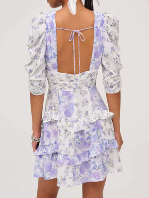 Ruched floral tie-front dress with puff sleeves and tiered ruffled skirt in purple and white.