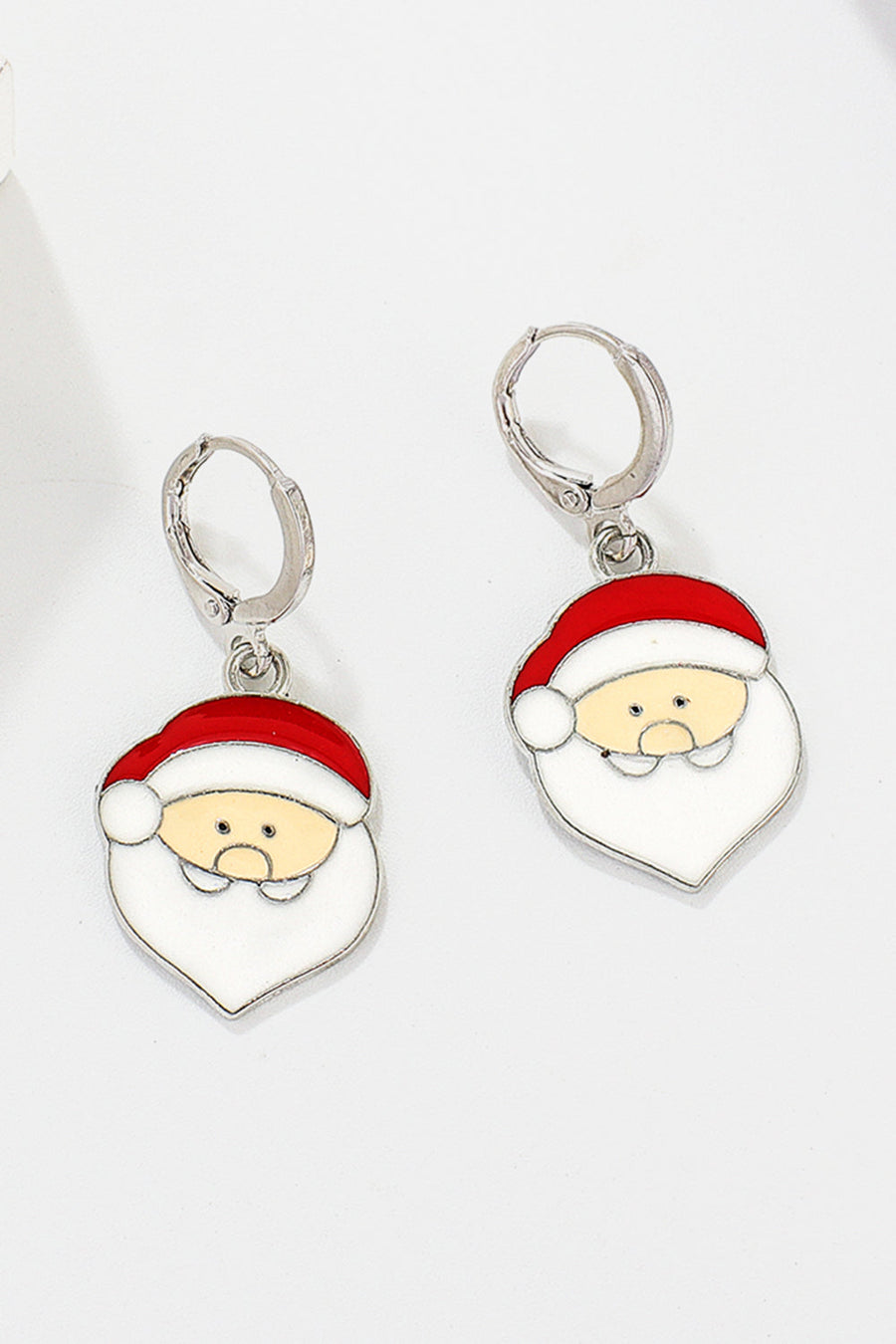Festive Santa charm hoop earrings in alloy with red and white enamel details.