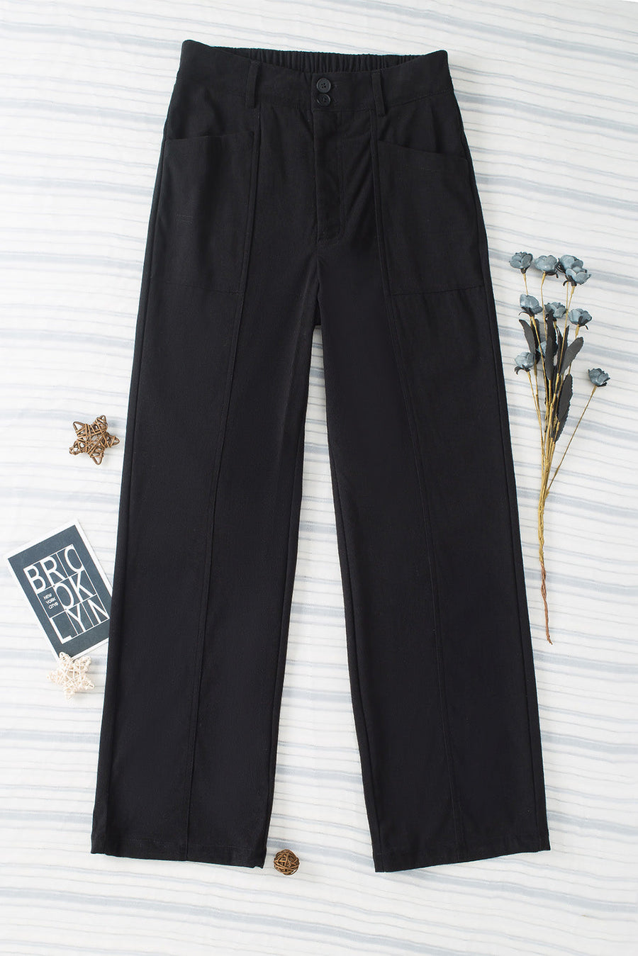 Black seamed front wide leg trousers with buttoned waist and pocket details.