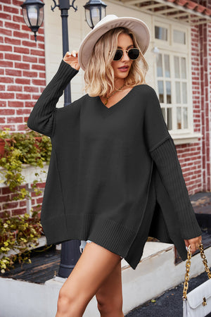 Black v-neck knit sweater with asymmetric slit hemline and ribbed sleeves.