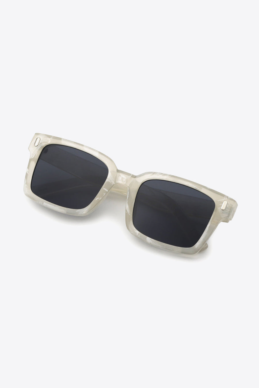 Marble effect rectangular sunglasses with dark lenses and a clear frame.