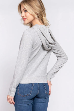 Grey graphic zip hoodie with a hood and long sleeves, worn with blue jeans.