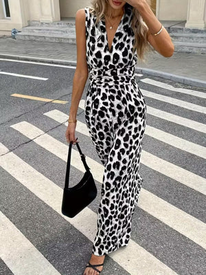 Sleeveless leopard print romper with V-neck and cinched waist, styled with a black shoulder bag.