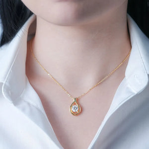 Gold teardrop pendant necklace with moissanite on a delicate chain.