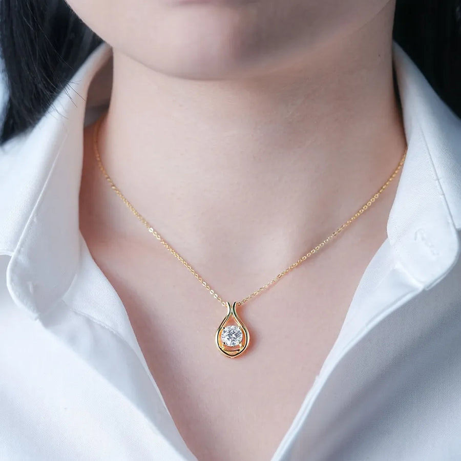 Gold teardrop pendant necklace with moissanite on a delicate chain.