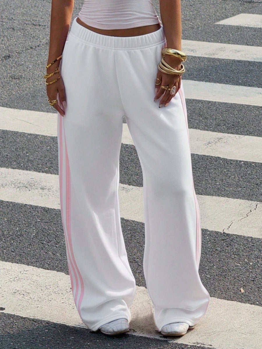 White track pants featuring high-waisted and striped