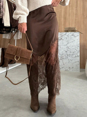 Brown satin skirt with asymmetrical lace trim and body-skimming fit.