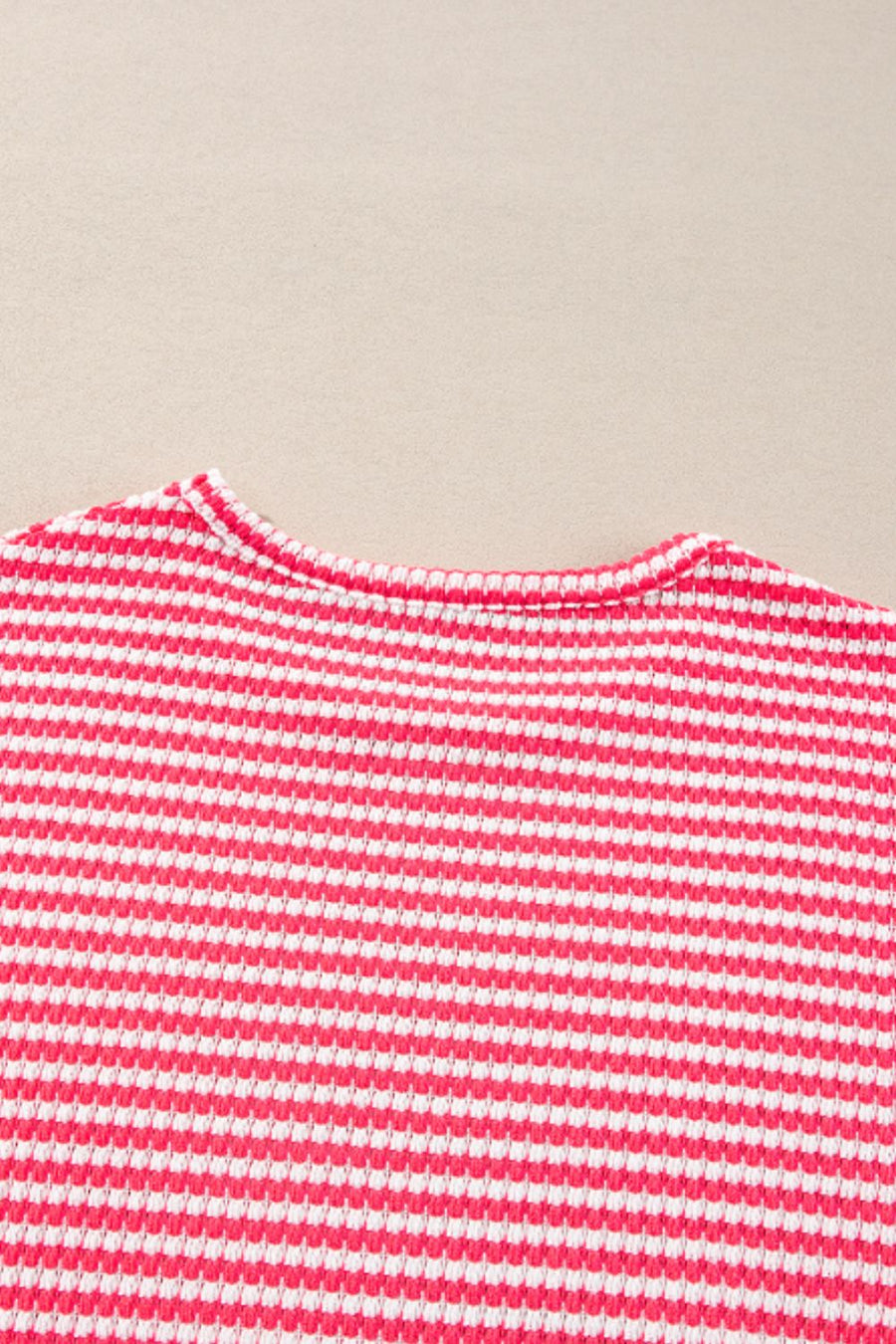 Pink and white striped textured top with crew neck and balloon sleeves.