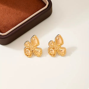 Gold earrings featuring flower design and floral