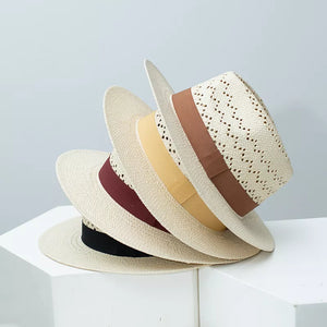 Straw boater hat with perforated crown and ribbon trim in brown, burgundy, ochre, and black.