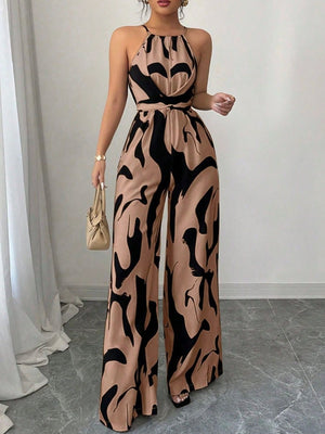 Elegant wide-leg jumpsuit in tan with abstract black print, halter neck, and draped bodice.